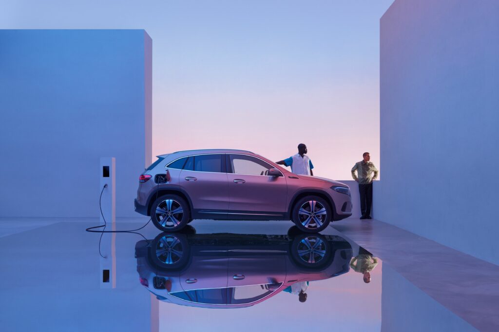 Cinematic image of two men watching their Mercedes-Benz EQC charge